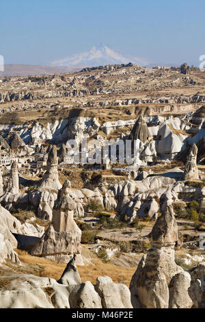 Volcanic rock formations known as Fairy Chimneys with Volcano Erciyes in the background, Turkey. Stock Photo