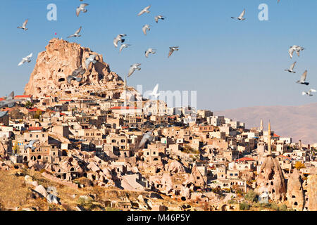 Uchisar castle in Cappadocia, Turkey with pigeons flying from the Pigeon Valley. Stock Photo