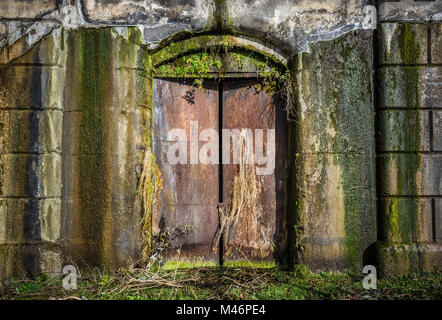 An old, weathered and damp cast iron door entrance to a Victorian lockup in Liverpool Uk. Stock Photo