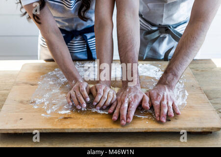 Couple kneading dough together. Stock Photo