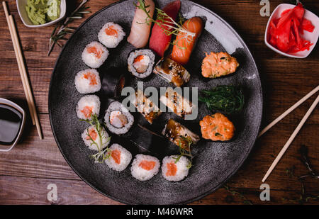 Sushi set nigiri and rolls served on brown wooden table background. Top view food photography. Stock Photo