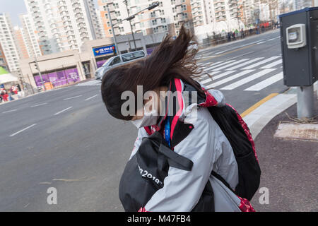 Gangneung, South Korea. 14th Feb, 2018. A volunteer fighting against the strong wind in Gangneung, South Korea, 14 February 2018. Credit: Peter Kneffel/dpa/Alamy Live News Stock Photo