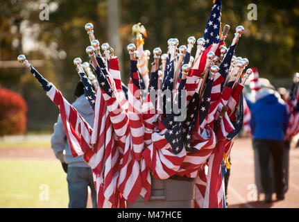 Worker pulling barrel full of rooled up American flags Stock Photo