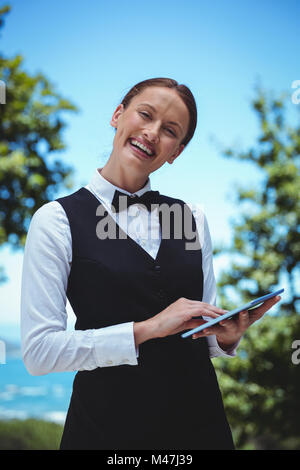 Smiling waitress taking an order with a tablet Stock Photo