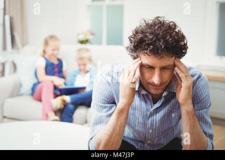 Close-up of tensed man while children in background Stock Photo