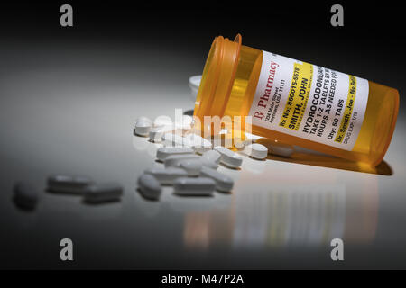 Hydrocodone Pills and Prescription Bottle with Non Proprietary Label. No model release required - contains ficticious information. Stock Photo