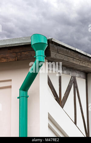 green drainpipe on wall of house Stock Photo