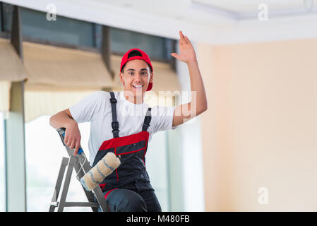 Young painter painting the ceiling in construction concept Stock Photo