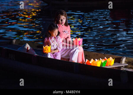 Vietnamese mother and daughter holding Lanterns before droping them into the River in Hoi An Vietnam Stock Photo