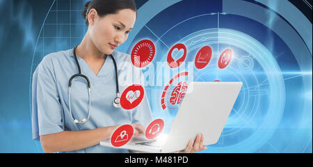 Composite image of concentrated surgeon using a laptop in hospital Stock Photo