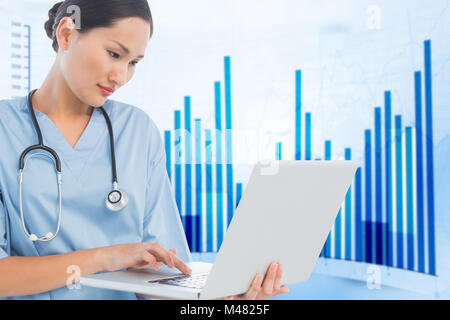 Composite image of concentrated surgeon using a laptop in hospital Stock Photo