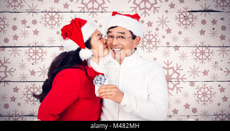 Composite image of festive senior couple exchanging gifts Stock Photo