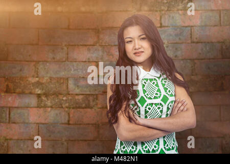 Composite image of asian woman with arms crossed Stock Photo