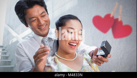 Composite image of man proposing marriage to his shocked girlfriend Stock Photo