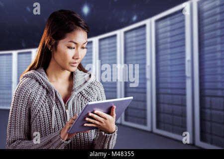 Composite image of focused asian woman using tablet Stock Photo
