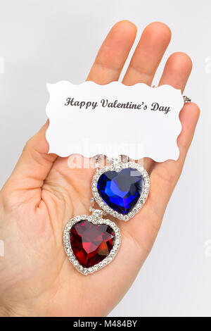 Hand showing red and blue jewelry hearts for valentine Stock Photo