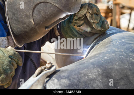 welder performs welding works on pipelines stainless steel Stock Photo