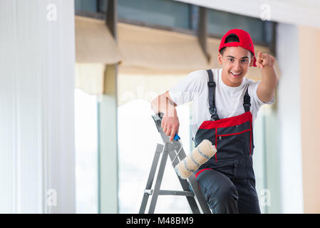 Young painter painting the ceiling in construction concept Stock Photo