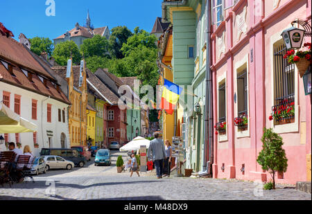 multi-colored houses of the old city of Sighisoara, the street paved stones, houses are painted multi-colored colors