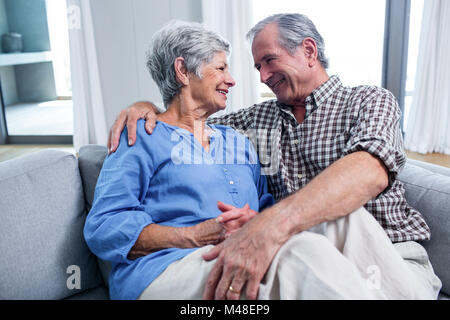 Happy senior couple embracing each other on sofa Stock Photo