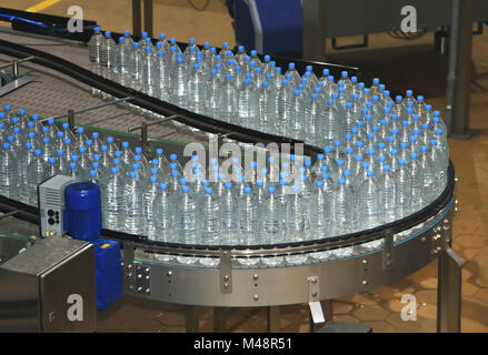 Plastic water bottles on conveyor and water bottling machine industry Stock Photo