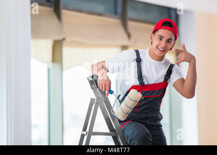 Young painter painting the ceiling in construction concept Stock Photo