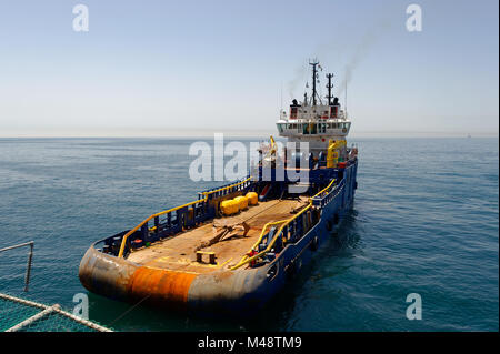 An anchor handling vessel (AHV) with an anchor on deck preparing to run ...