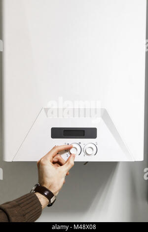man regulate heating boiler control panel Stock Photo