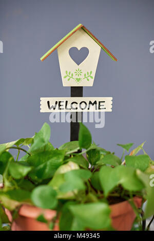 Welcome home sign on blue plan background. Pretty wooden bird house Stock Photo