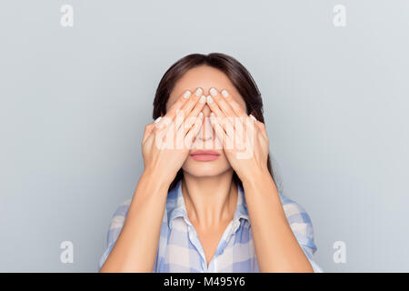 Close up portrait of tired woman after long working day on computer having eye problem, pressure, covering face, eyes with hands, afraid to look, stan Stock Photo