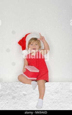 little girl in Santa suit, snowflakes with gift Stock Photo