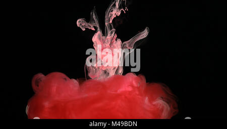 Red Ink Paint in Water Creating Liquid Artistic Shapes Stock Photo
