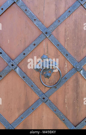 Door handle-knocker on the vintage metal dark grey door Stock Photo