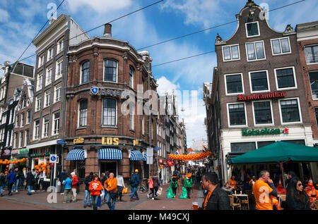 Amsterdam, Netherlands - 27 April, 2017: Streets of Amsterdam with orange decorations full of people in orange during the celebration of kings day. Stock Photo