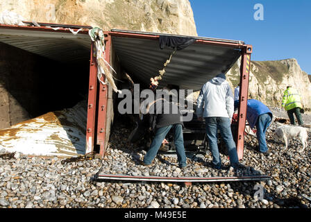 Branscombe Beach, Devon, England. People salvage contents from the striken and grounded container ship MSC Napoli washed up on the beach. 23.01.07 Stock Photo