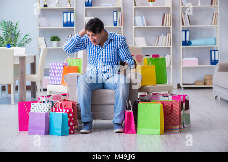 Young man after excessive shopping at home Stock Photo