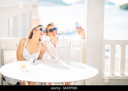 Attractive couple having first date.Coffee with a friend.Smiling happy people making a selfie with a smartphone.Sharing on social media.Technology Stock Photo