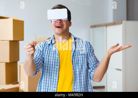 Young man wearing VR glasses moving in new apartment Stock Photo