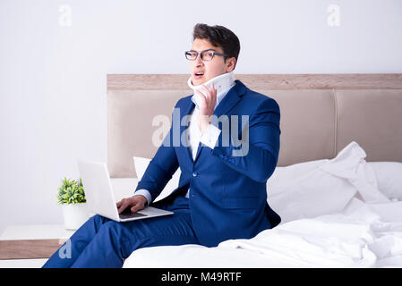 Businessman with neck injury working from home Stock Photo