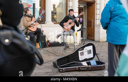 Street musicians busking playing guitars in Chichester, West Sussex, England, UK. Stock Photo