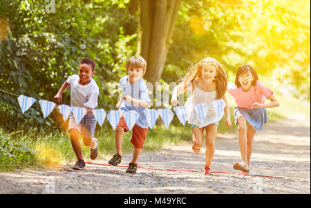 Group of kids makes race competition in summer in the garden Stock Photo