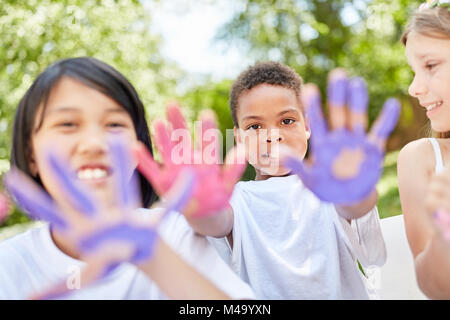 Children in international kindergarten play and paint with finger paints Stock Photo