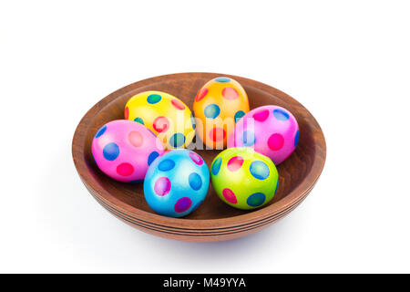 Various painted chicken easter eggs in wooden bowl on white Stock Photo