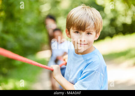 Determined boy at the rope pulling competition in summer camp Stock Photo