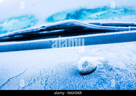 Iceflowers, frozen.The ice-cold frost forms ice crystals in beautiful unique patterns on the window, Hood and wiper on the Car Stock Photo