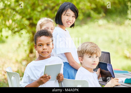 Multicultural group of pupils in computer course is learning together in the garden Stock Photo
