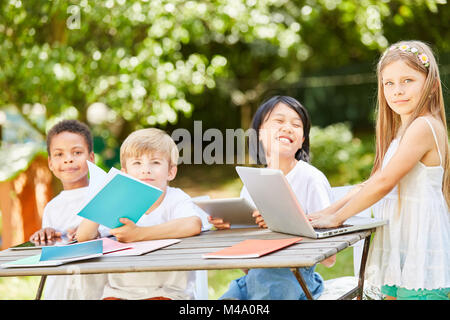 Group of kids in computer course of a primary school or preschool in the garden Stock Photo