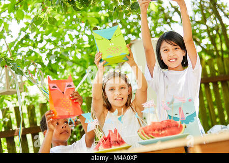 Children hold up gift bags as a surprise on a children's birthday party Stock Photo