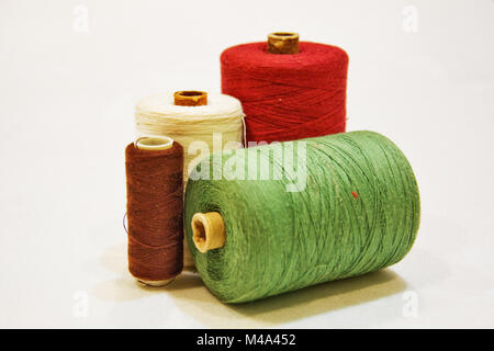 Spools of thread of different colors on a white background Stock Photo