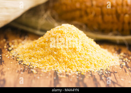 Corn groats and seeds, corncobs on wooden rustic table Stock Photo